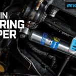 A high-quality steering stabilizer installed on the front suspension of a Ford F250 truck.